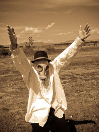 Kid in a gas mask arms raised in a field.の写真素材