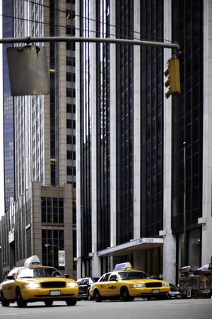 NYC traffic, yellow taxis and tall skysraper buildings