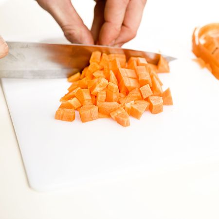 orange carrot been slided and diced in a kitchenの写真素材