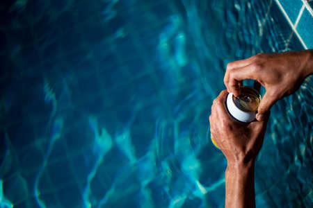 Selective focus white beer can in hand. Man is soaking in the pool with an open beer can relax and...