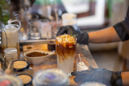 Focus only on the ice point in a glass of iced coffee mixed with orange juice. Looks delicious, smells fresh. Refreshing coffee mixed with fruit juice drinks in a coffee shop.の写真素材