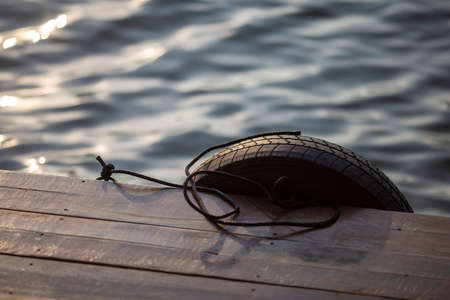 Old car tires used at the pier To make the boat dock soft, prevent shock. Photo for background selective focusの写真素材