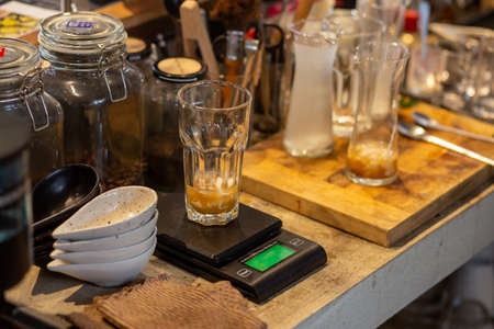 Close up the lemonade drink with ice in a clear glass beside a glass tube and the laboratory, adjust...