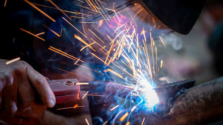 Industrial workers at a close-up welding plant