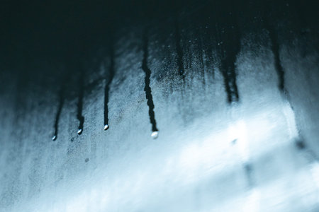 A water droplet condensation moisture wet surface closeup abstract blue cold liquid texture create serene and cool atmosphere with water droplets forming on smooth surface