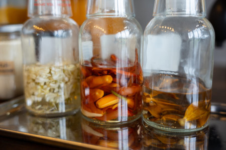 Herb infusion spice infusion chili infusion glass bottle transparent liquid kitchen homemade aromatic ingredient closeup natural preserved culinary preparation flavor organic yellow red brown