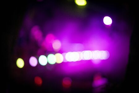 Bokeh lights appearing from a pink and purple mist at night