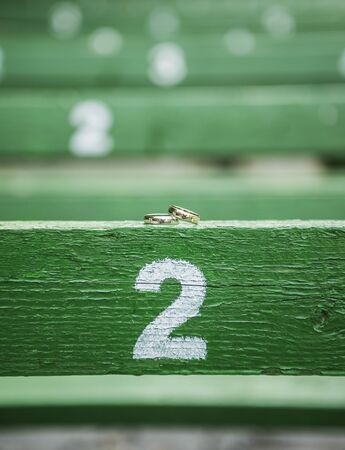 wedding rings on a wooden background in a stadiumの写真素材