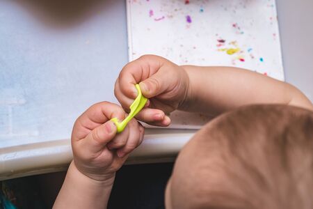 The child sculpts teeth from plasticine. Child's hands with colorful clay. Plastiline.の写真素材