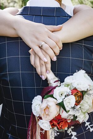 Delicate wedding bouquet of roses in the hands of the bride at the bottom. General view.の写真素材