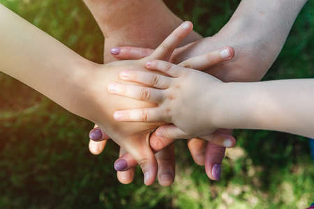 family teamwork, hands on top of each other top view, summer sports mood. Close up