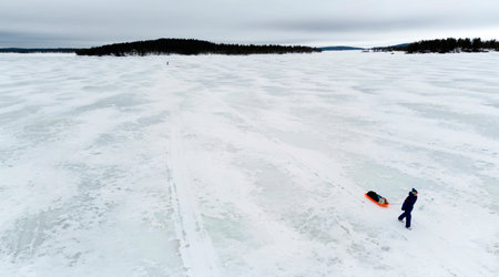 Hiking on a frozen lake using a pulka for carrying supplies