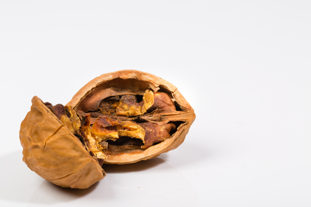 Cracked dried walnut in halves on white background