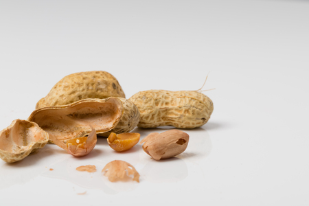 Cracked Dried Peanut in halves on white backgroundの写真素材