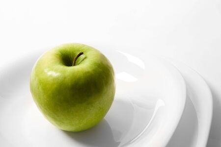 green apple on a white plateの写真素材