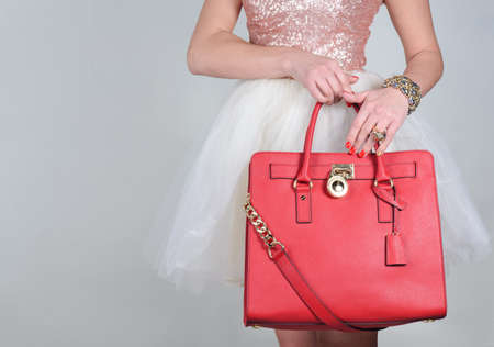 Red stylish glamorous female leather bag on pure background. Fashionable and high style expensive female bag. Sales bag fashion conceptの写真素材