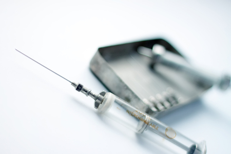 An old glass syringes and a metal box.の写真素材