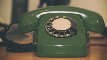 Old green rotary phone on the desktop.の写真素材