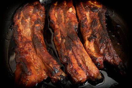 Juicy fried pork ribs in a pan