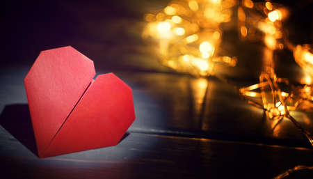 Origami heart on wooden background with festive lanterns for Valentines Dayの写真素材
