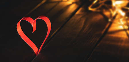 Red paper heart on wooden background