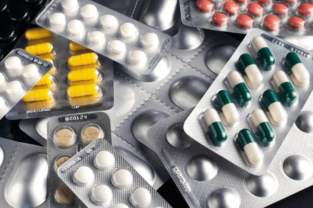 Medicines and pills in blisters are scattered on the tableの写真素材