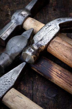 Old hammers on a wooden workbenchの写真素材