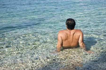 Man sitting in the sea and relaxingの写真素材
