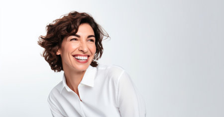 Smiling happy woman in her 40s with chestnut hair on a white backgroundの写真素材
