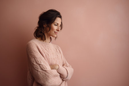 Portrait of a beautiful woman in a pink sweater on a pink backgroundの素材
