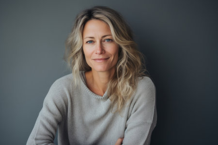 Portrait of a middle-aged woman in a gray sweater on a gray backgroundの素材
