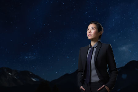 Asian businesswoman standing against starry night sky with Milky way backgroundの素材