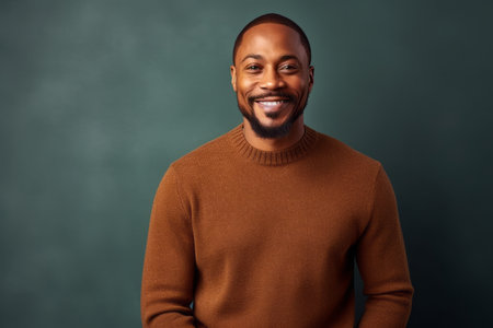 happy african american man in sweater looking at camera on blackboardの素材