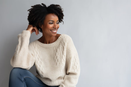 Portrait of a smiling young african american woman sitting on a chairの素材