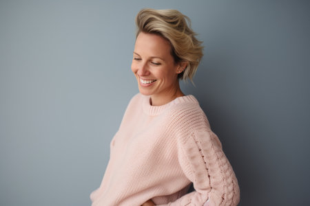 Portrait of a beautiful young woman with short blonde hair on gray backgroundの素材