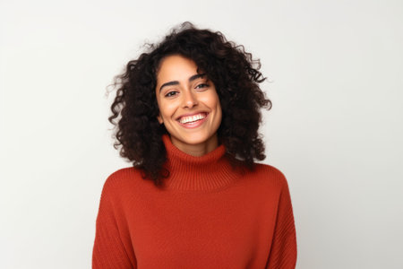 Portrait of a beautiful young african american woman smiling against white backgroundの素材