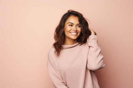 Portrait of a beautiful young woman smiling at camera isolated over pink backgroundの素材