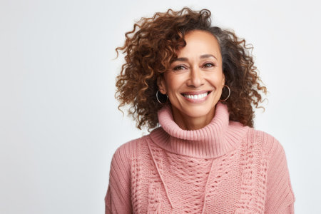 Portrait of a happy young woman smiling at camera over white backgroundの素材