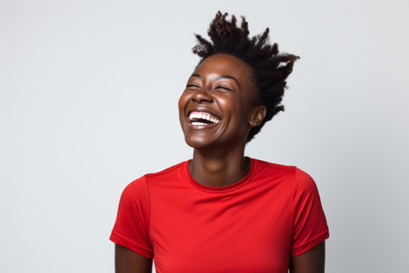 Portrait of a happy african american woman laughing over white backgroundの素材
