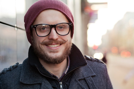 Young smiling hipster with moustache, beard and glassesの写真素材