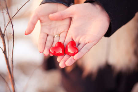 Lovers couple are holding pair of hearts in their hands as a symbol of loveの写真素材