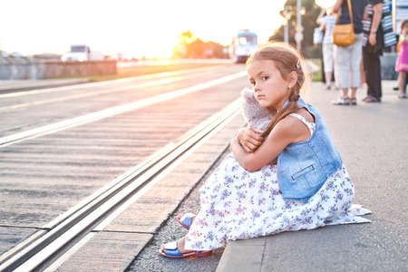 Lonely girl on a city tram stationの写真素材