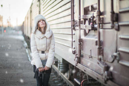 Stylish woman in snowy day on a platformの写真素材