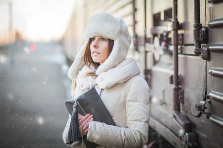 Pretty girl in winter blizzard on railroad stationの写真素材