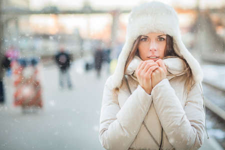 Youn woman on a train station in winterの写真素材