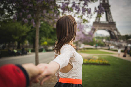Romantic brunette woman is holding by the hand her boyfriendの写真素材