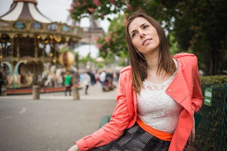 Sexy woman is sitting on the bench near eifel tower carouselの写真素材