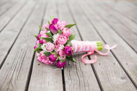 Pink and Purle tender flowers with ribbon on a wooden patternの写真素材