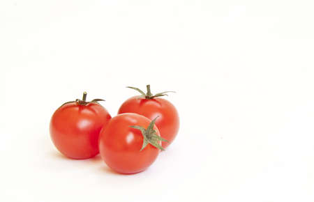Tree red cherry tomatoes isolated on white backgroundの写真素材