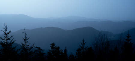 Amazing blue panorama background banner long from a fog landscape in the morning in black forestの写真素材